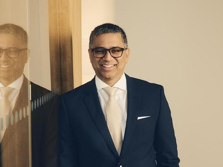 Portrait von Shashank Deshpande. Angelehnt an eine Glaswand, sodass eine Spiegelung seines Oberkörpers entsteht.