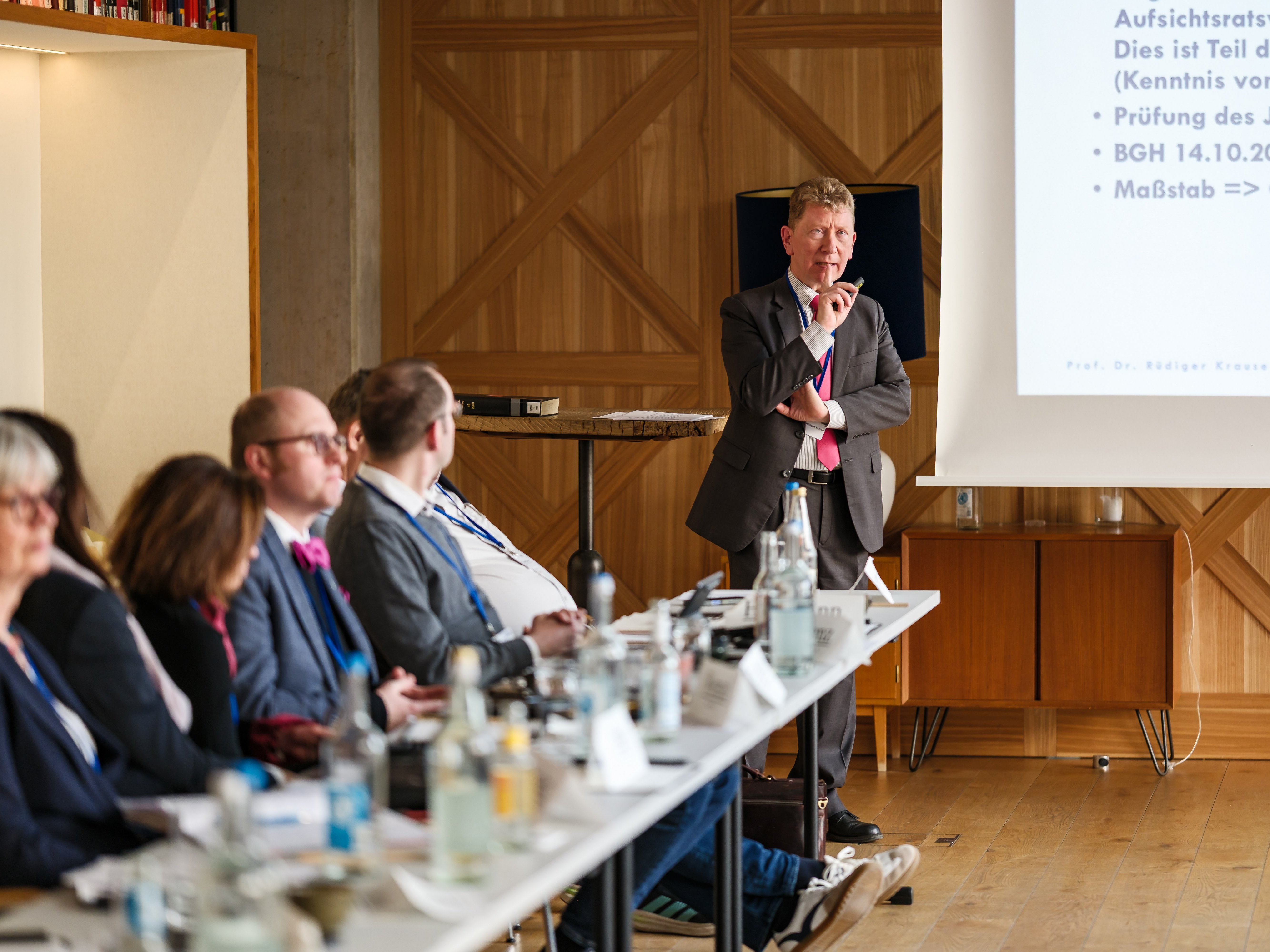 Im Vordergrund das Plenum, im Hintergrund, aber scharf Prof. Rüdiger Krause beim Vortrag.