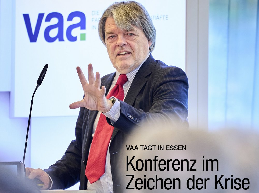 Cover des VAA Magazins, Ausgabe Dezember 2025: Das Coverfoto zeigt Denis Hicks bei der VAA-Jahreskonferenz. Mitte rechts die Headline: „Konferenz im Zeichen der Krise“.