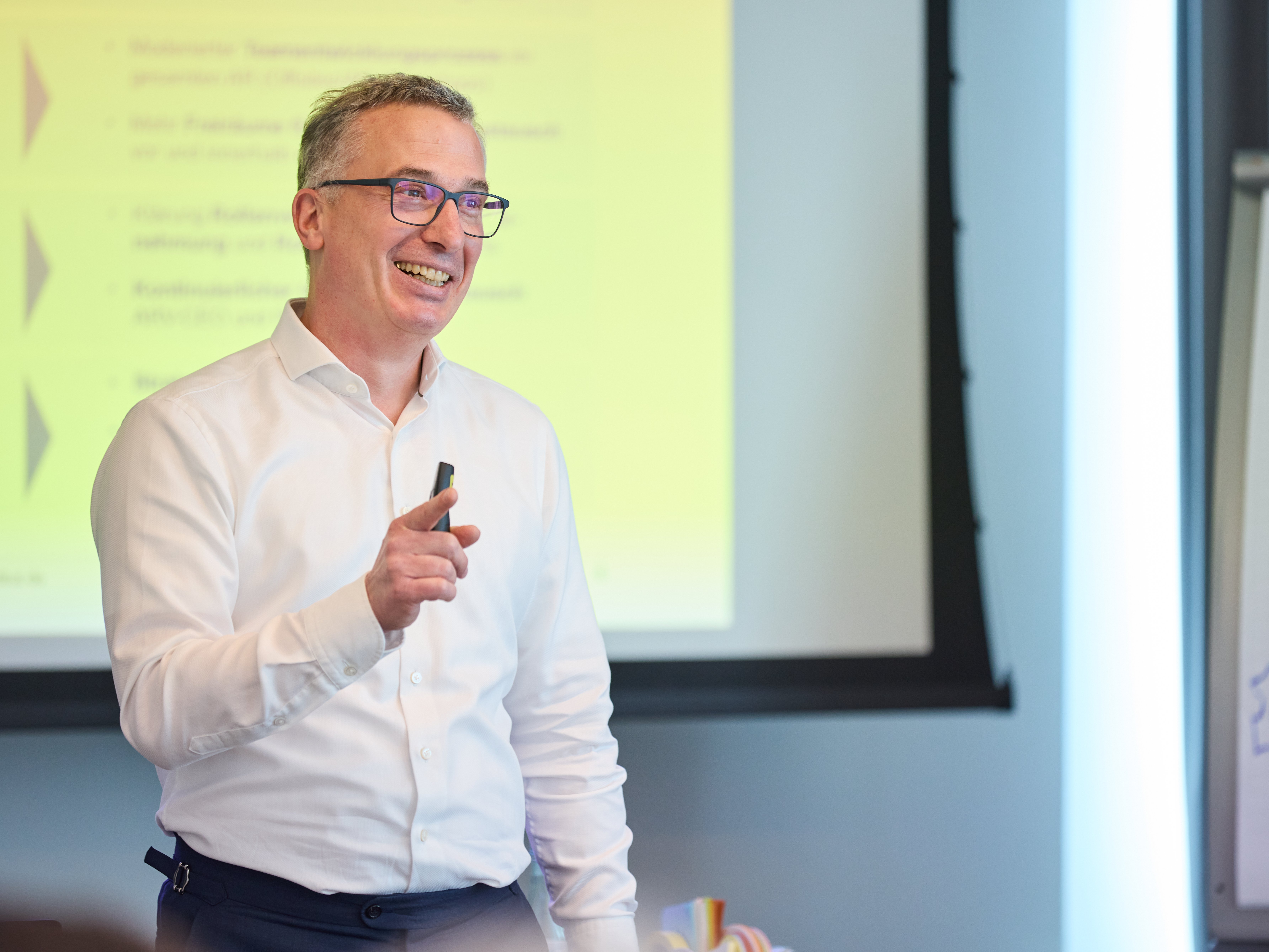Prof. Peter Ruhwedel bei seinem Vortrag. Im Hinzergrund die Präsentation auf Leinwand.