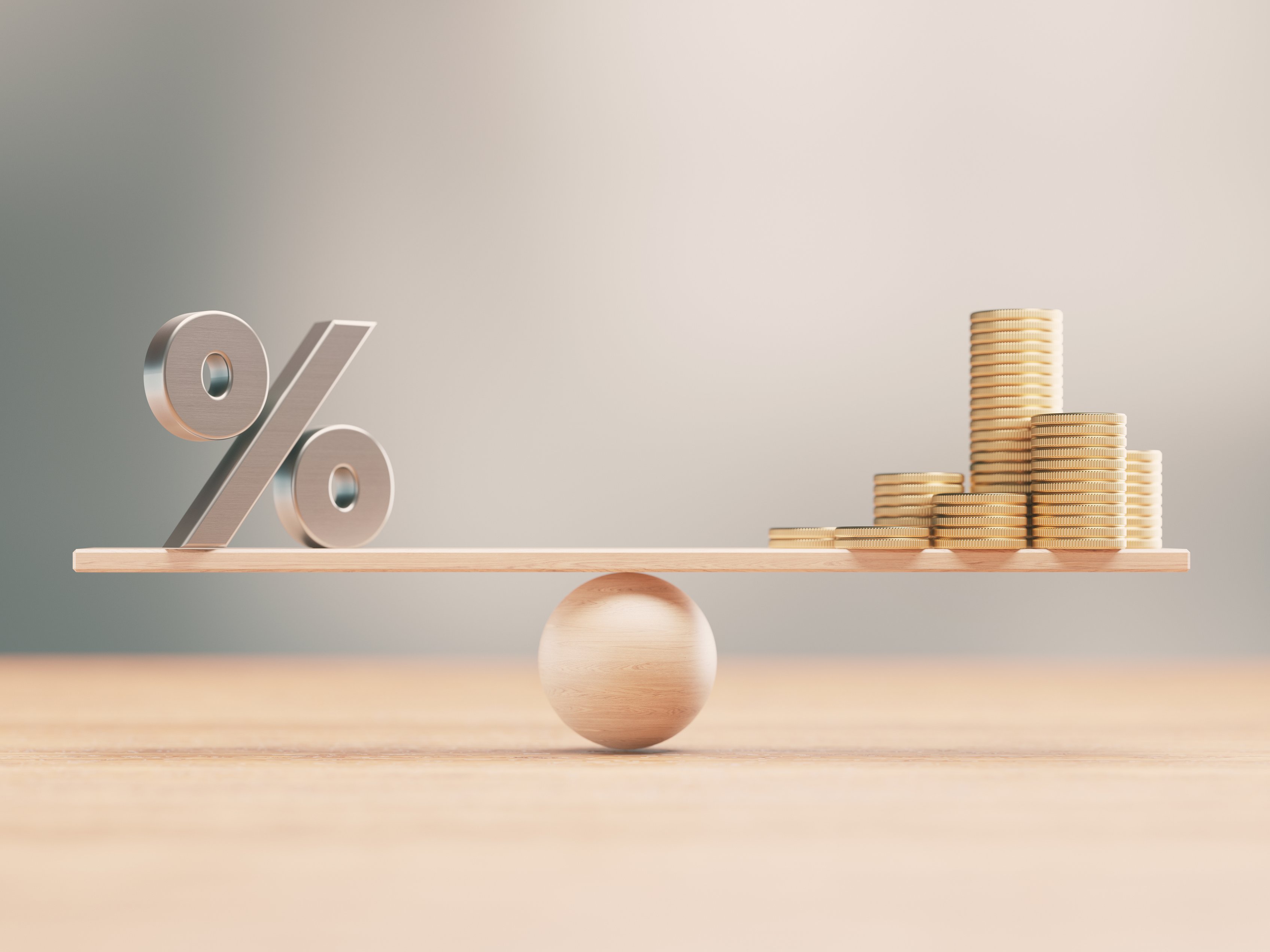 Symbolbild mit Prozentzeichen und Münzen auf einer Wippe