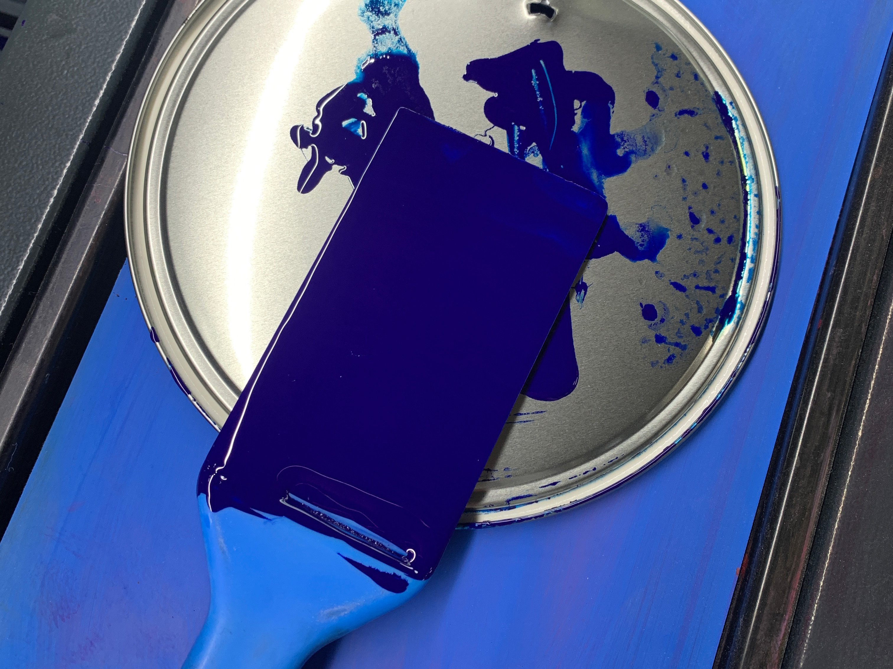 Ein Pinsel in blauer Farbe in einer Druckerei.