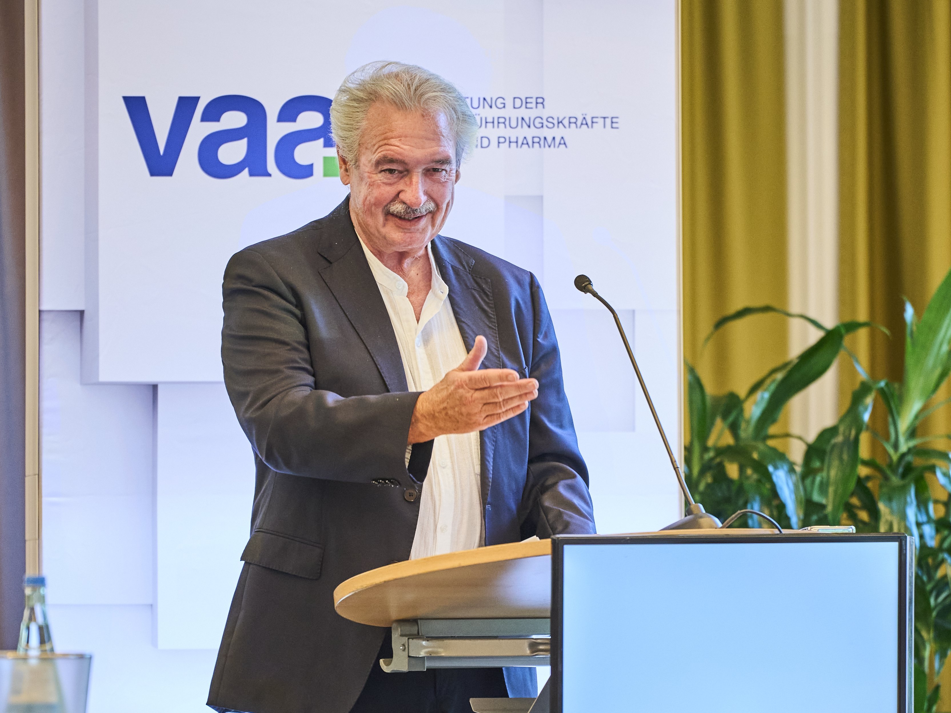 Jean Asselborn am Rednerpult mit VAA-Logo.